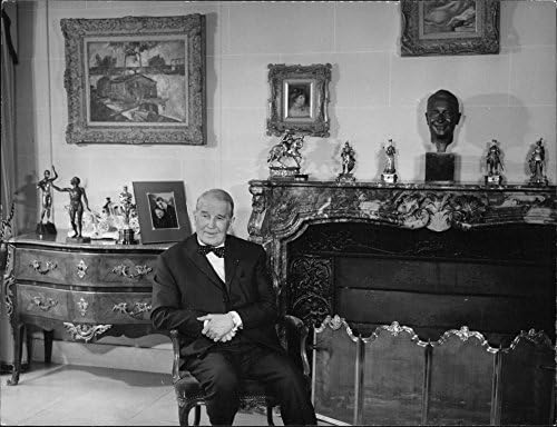 Vintage fotografija Mauricea Chevaliera kako sjedi na stolici.